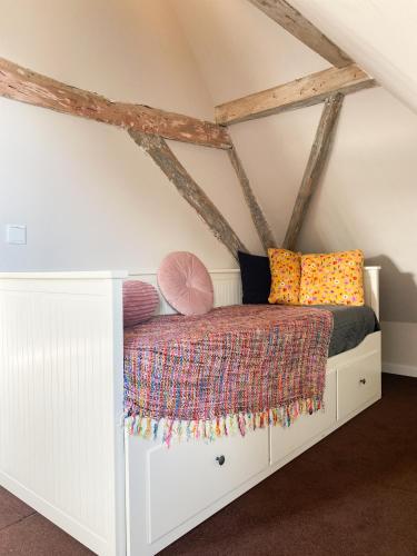a bed in the corner of a room in a attic at Huize de Lekpoort - The Stork Loft - Loft Apartment in Vianen Center in Vianen