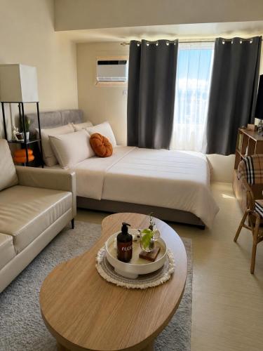 a living room with a bed and a coffee table at The Nook at Avida Towers 2 CDO in Cagayan de Oro