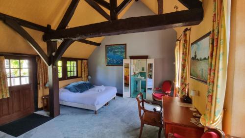 a bedroom with a bed and a chair in a room at Les Maisons de Mélody in Houlbec-Cocherel