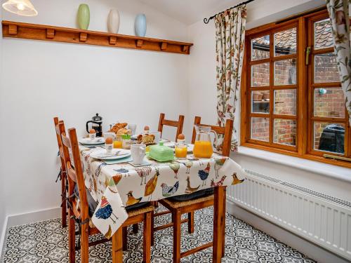 a dining room with a table and chairs at Flint Cottage in Saxmundham