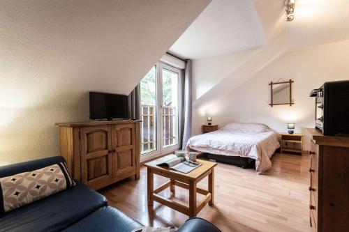 a living room with a bed and a tv at Studio 766 – LA TARENTAISE in Brides-les-Bains