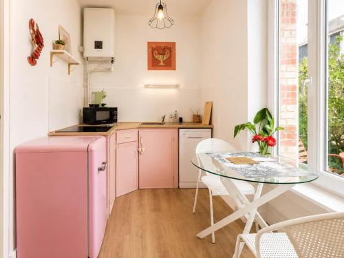a kitchen with a pink refrigerator and a table at Charmant Studio au cœur de Dinard in Dinard