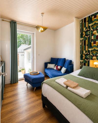 a bedroom with a bed and a blue couch at Charmant Studio au cœur de Dinard in Dinard