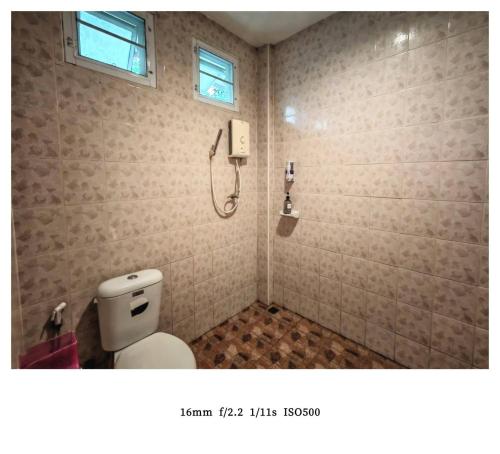 ein Badezimmer mit Toilette und Telefon an der Wand in der Unterkunft king s hotel in Mae Sot