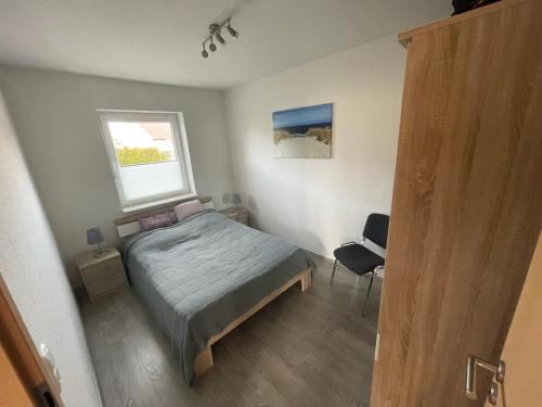 a small bedroom with a bed and a window at Am Wangermeer 14 in Wangerland
