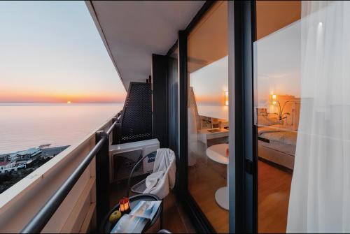 a room with a balcony with a view of the ocean at Panorama Batumi Black Sea View in Batumi
