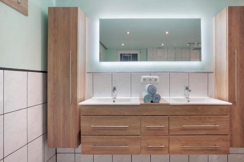 a bathroom with two sinks and a mirror at Ferienwohnung Schaule in Bolsterlang