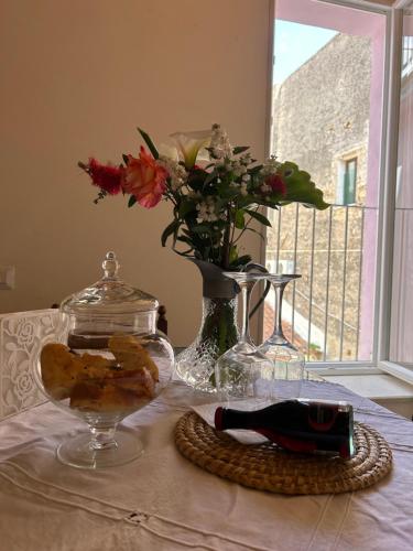a table with a vase and a glass bowl with flowers at B&B Casa CamiLory in San Lucido