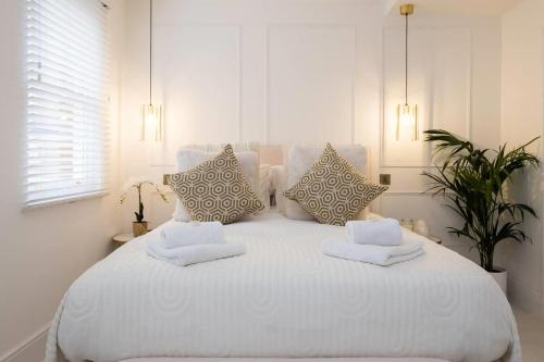 a white bedroom with a large white bed with pillows at Beeches Retreat in Shrewsbury