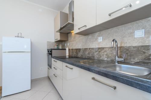 a kitchen with a sink and a refrigerator at Apartments Andrija in Palit