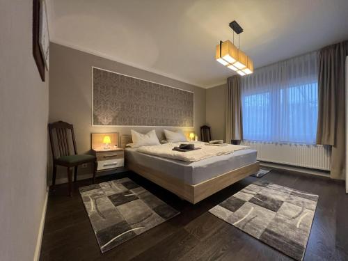 a bedroom with a large bed and a chair at Haus Rosenwind in Wangerland