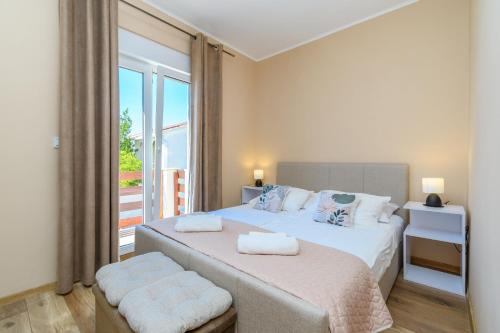 a bedroom with two beds and a balcony at Apartments Andrija in Palit