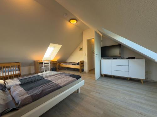 a bedroom with a bed and a television in a attic at Minser Deichhaus in Wangerland