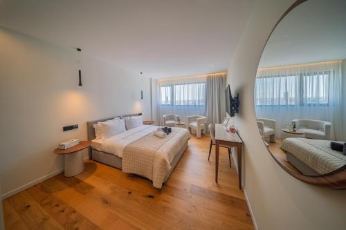 a hotel room with a bed and a mirror at Sky Suites Nicosia in Strovolos