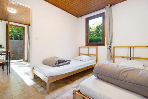 two beds in a room with a table and chairs at 4.Les Chenes option Clim- 4 pers in Calviac