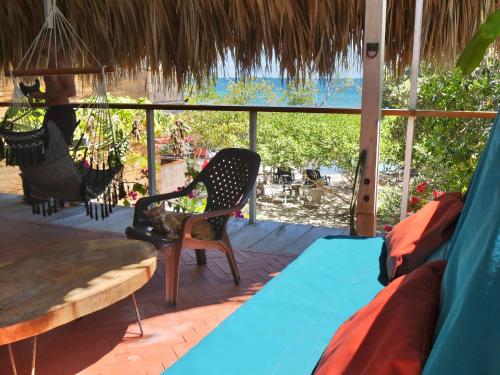 a room with a hammock and a table and chairs at Santa Lova Eco-hostel Isla Tintipan in Tintipan Island