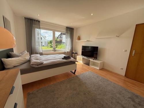 a bedroom with a bed and a large window at FeWo am Baunsberg in Baunatal