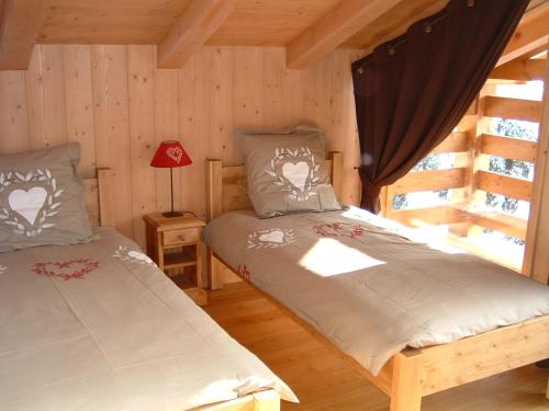 une chambre avec deux lits dans une cabane en rondins dans l'établissement Chalet Le Solaret, à Megève