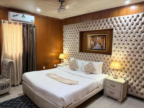 a bedroom with a large bed in a room at Palm East Hotel in Lahore