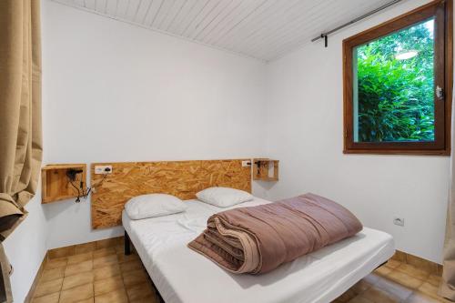 a bed in a room with a window at 1.Chataigniers option clim- 4pers in Calviac