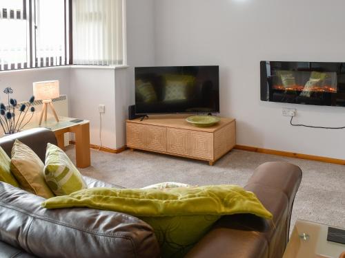 a living room with a couch and a flat screen tv at Turnstones in Walcott