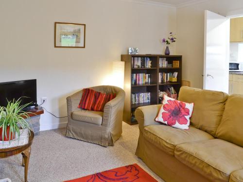 a living room with a couch and a chair at Beuchan Cottage Keir Mill in Closeburn
