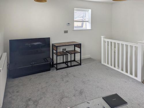 a living room with a flat screen tv and a table at Martin - Uk48161 in Filey