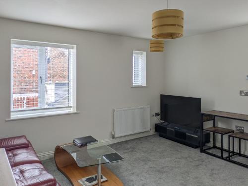 a living room with a couch and a flat screen tv at Martin - Uk48161 in Filey