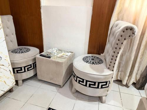 a room with two chairs and a table at Palm East Hotel in Lahore