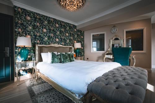 a bedroom with a large white bed with a green accent wall at The Inn At Grasmere & The Little Inn in Grasmere