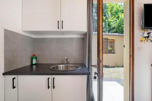 a kitchen with a sink and a door to a yard at 16. Les Sources option clim- 2 pers in Calviac