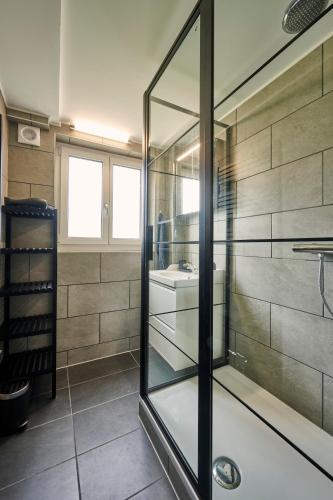 a glass shower in a bathroom with a sink at Clarke's Lakeside Chalet 1 in Leissigen