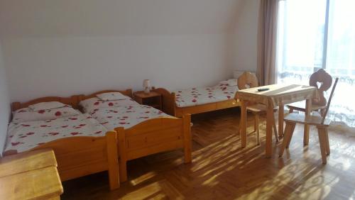 a bedroom with two beds and a table and a desk at Willa Cachro in Zakopane