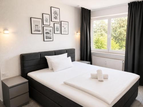 a bedroom with a large white bed with a window at Lipp Apartments in Cologne