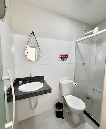 a bathroom with a toilet and a sink and a mirror at Studio #3 Rubi in Campos dos Goytacazes