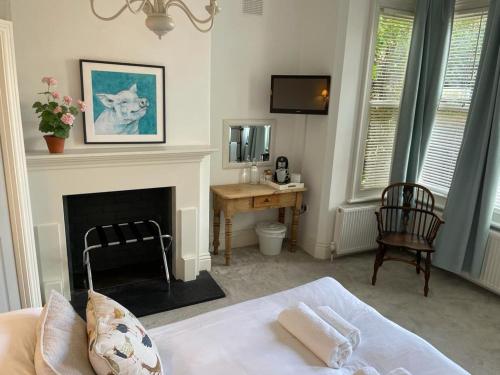 a bedroom with a bed and a desk and a fireplace at Poplars Farm in Henlow