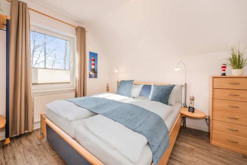 a bedroom with a large bed and a window at Seeblick Leuchtturm in Koserow