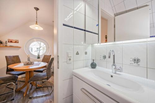 a bathroom with a table and a sink and a tub at Seeblick Leuchtturm in Koserow