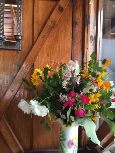 a vase filled with flowers sitting on a table at The Hermitage Kanatal in Kanatal