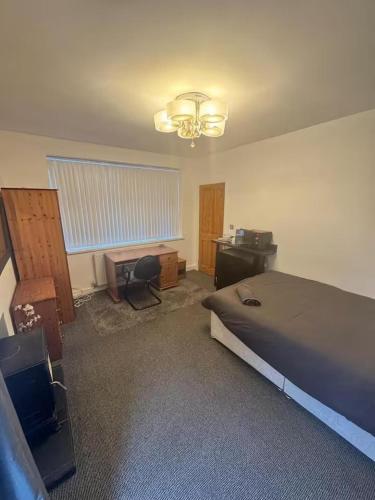 a bedroom with a bed and a desk and a desk at Studio sleeps 2 with Parking in Derby