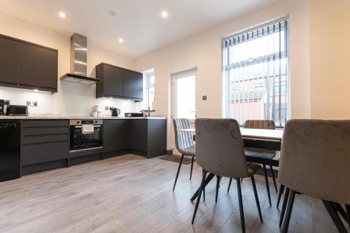 a kitchen and dining room with a table and chairs at Urmston House in Leigh