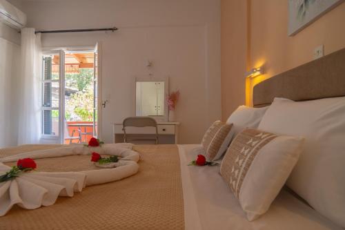 a bedroom with two beds with red roses on them at Lisipio Studios by Eleni in Paleokastritsa