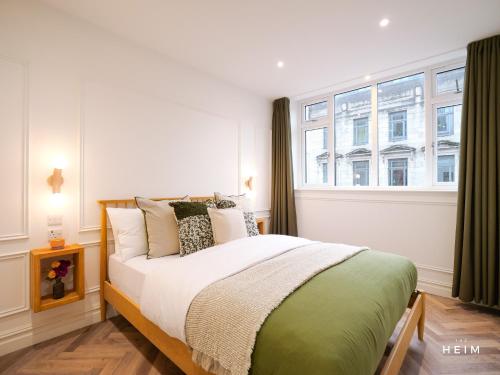 a bedroom with a bed and a large window at The Heim Aparthotel in Manchester