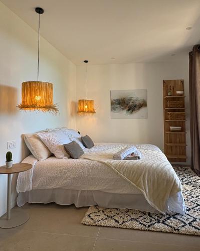 a bedroom with a bed with two lamps and a table at Villa Loka-Ecrin contemporain Adult only in Sauzet