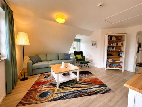 a living room with a couch and a table at Inselglück Föhr in Wrixum