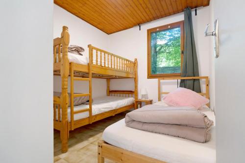 a bedroom with two bunk beds and a window at 17.Les Etoiles option Clim- 7 pers in Calviac