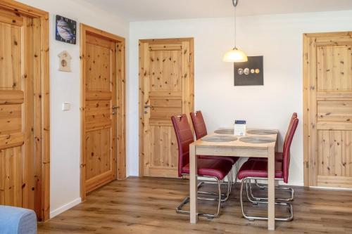 a dining room with wooden doors and a table and chairs at Ferienhaus Jupiter im Sternenpark in Lochow