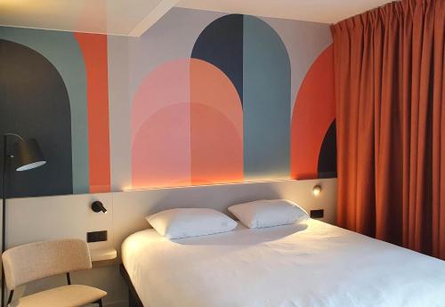 a bedroom with a bed and a colorful wall at B&B HOTEL Hasselt in Hasselt