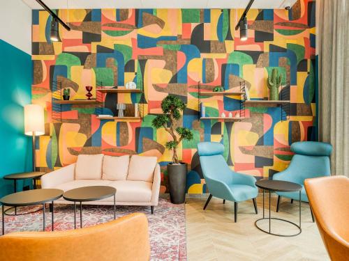 a living room with a couch and a colorful wall at B&B HOTEL Namur in Namur