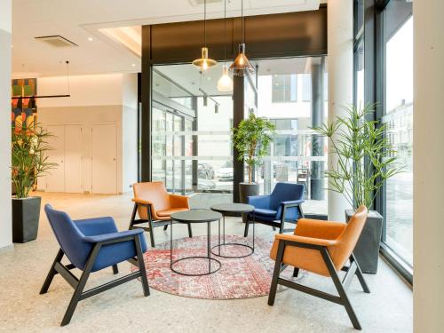 a group of chairs and tables in a lobby at B&B HOTEL Namur in Namur